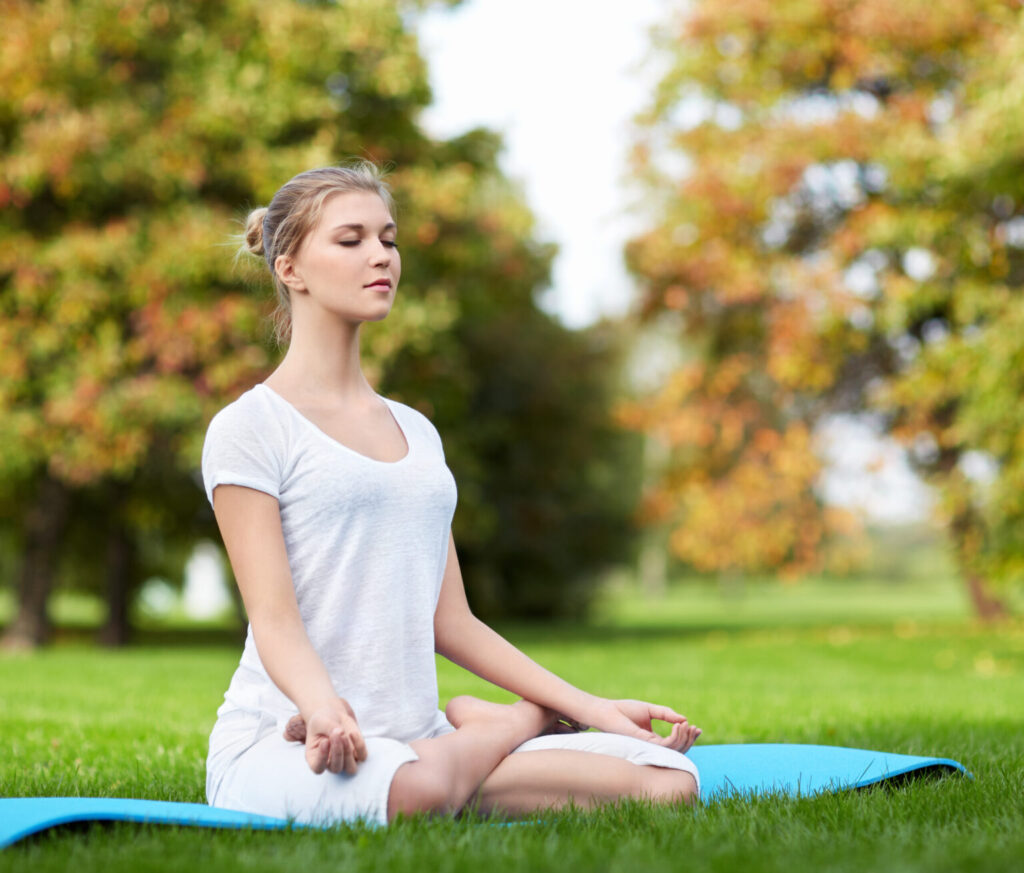 Young girl doing yoga in the park